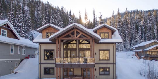 Outside view of a timber frame log home in the snow