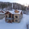 Side view of the outside of a timber frame log home in the snow